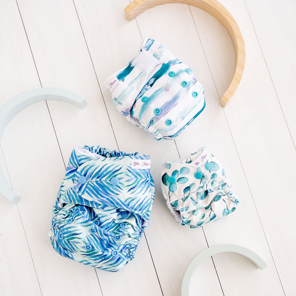 Three hand-illustrated cloth nappies in blue tones which have been hand-illustrated